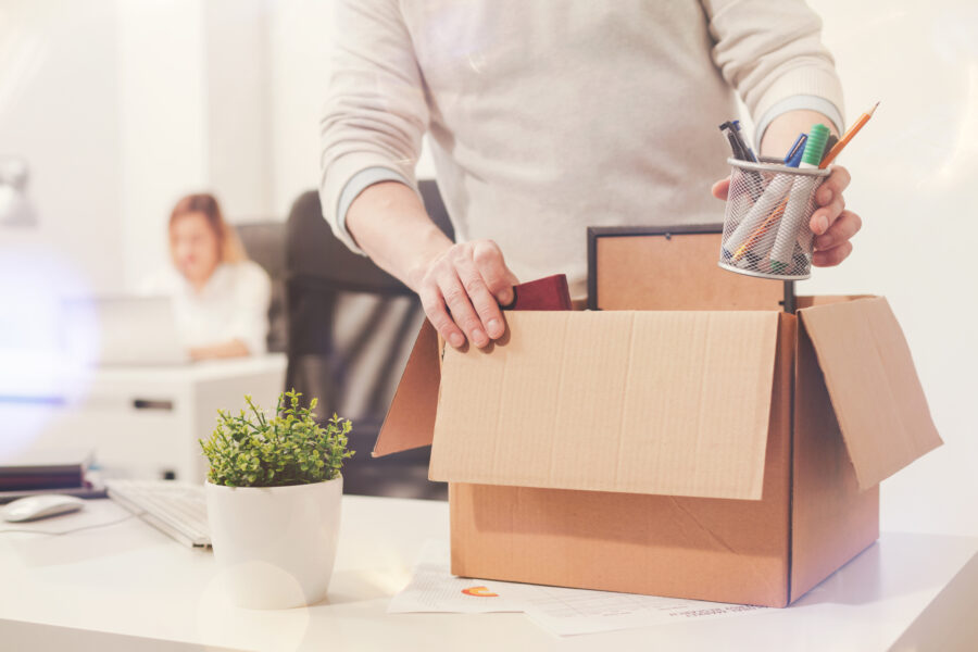 Man Putting Things in Box on Desk to Downsize Office in Weston, Boca Raton, Broward, Palm Beach, Pompano Beach, Plantation, FL, and Nearby Cities 